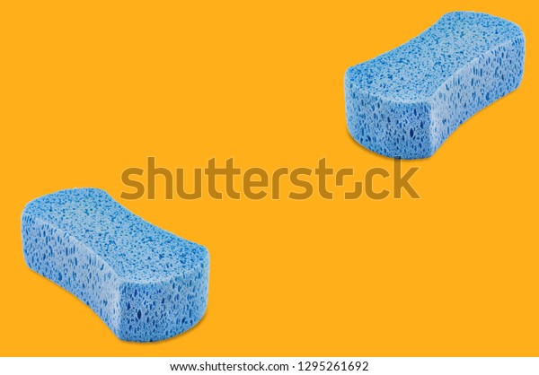 Pair of porous blue sponges yellow background with\
copy space for your text