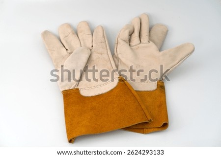 A pair of protective work gloves crafted from a combination of natural leather and suede leather, ideal for welding, construction, and industrial applications. Displayed on a white background