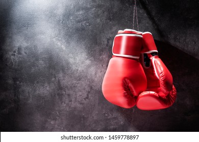 Pair of red boxing gloves hanging on the wall