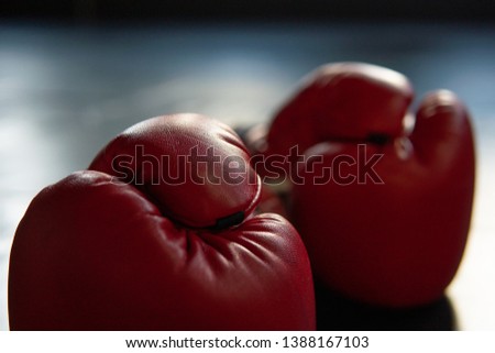 Pair of red boxing gloves in Boxing ring