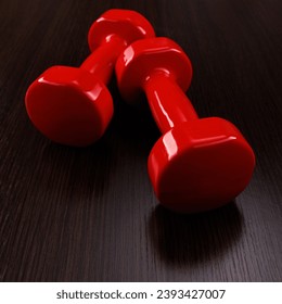 A pair of red dumbbells lies on a wooden surface. Angle view. Selective focus. - Shutterstock ID 2393427007