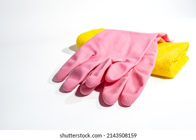 A pair of ribbed pink rubber cleaning gloves and a yellow microfiber cloth. Set of cleaning accessories isolated on white background. - Powered by Shutterstock