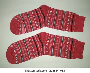 
A Pair Of Rolled Up Socks, Red And Striped. On A White Background