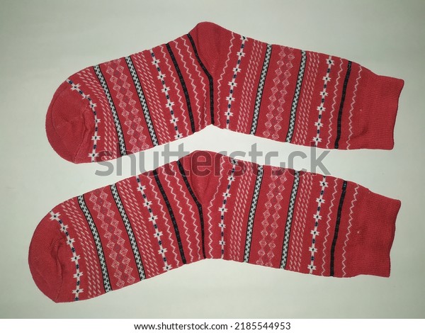 \
a pair of rolled up socks, red and striped.\
on a white background