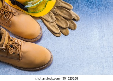 Pair Of Safety Lace Boots Leather Gloves Hard Hat And Working Goggles On Scratched Metallic Background Construction Concept.