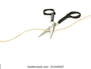 Pair Of Scissors Cutting A Length Of Brown String