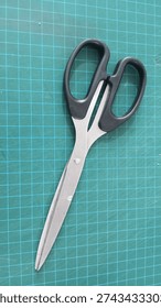 a pair of scissors on a green work table