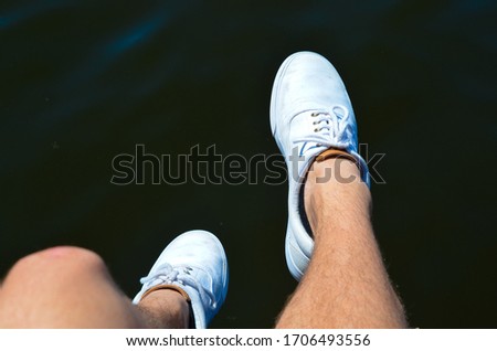 Pair of shoes dangling off a dock