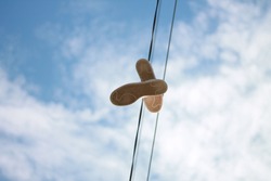 A Pair Of Shoes Hangs From A Telephone Wire, The Blue Sky Above Them