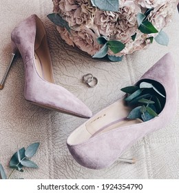 A Pair Of Shoes, Pink Color. Wedding Shoes. Wedding Bouquet With Pale Pink Roses And Leaves Of Eucalyptus. Two Rings Are In The Center. Marriage. No People