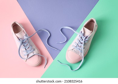 Pair Of Shoes With Untied Laces On Color Background