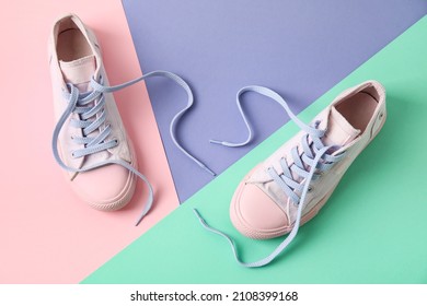 Pair Of Shoes With Untied Laces On Color Background