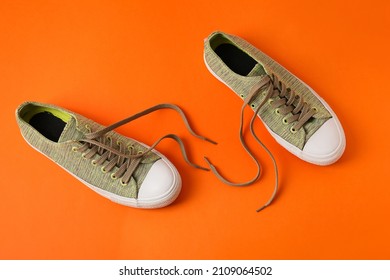 Pair Of Shoes With Untied Laces On Orange Background