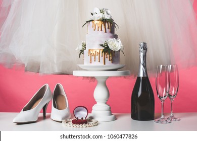 Pair Of Shoes, Wedding Cake And Champagne Isolated On Pink