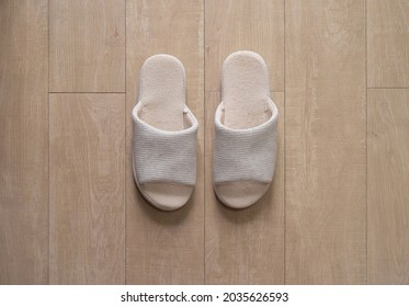 Pair Of Shoes. White Slippers Isolated On Wooden Floor. Objects Used In A Bedroom