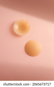 A pair of silicone sticker pad to cover nipples on pink background