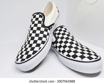 A Pair Of Slip-on Checkerboard Shoes Style In With Clean Background