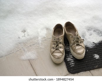 A Pair Of Sneakers On A Door Mat, Covered With Snow