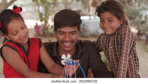 A Pair Of South Asian Children And A Teacher Playing With Educational Toys Together