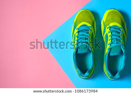 Pair of sport shoes on colorful background. New sneakers on pink and blue pastel background, copy space. Overhead shot of running shoes. Top view, flat lay