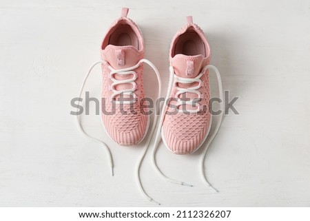 Pair of sportive shoes with untied laces on light wooden background 商業照片 © 