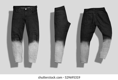 Pair of straight men's jeans with black to white gradient color shot from the front and the back and folded in half isolated on white.