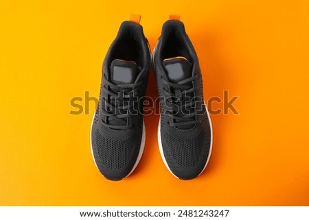 Pair of stylish sneakers on a color background
