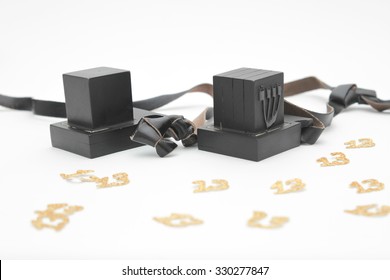 pair of tefillin and Tallit A symbol of the Jewish people, a pair of tefillin with black straps, isolated on a white background, with room for text. (Bar Mitzvah Jews 13 years old)