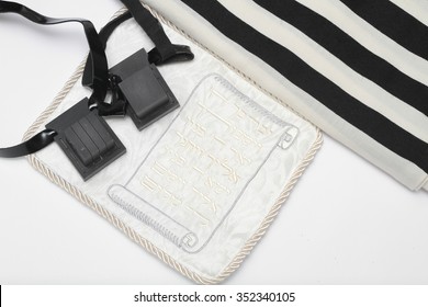 pair of tefillin and Tallit A symbol of the Jewish people, a pair of tefillin with black straps, isolated on a white background