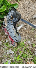 a pair of thrown away wheel inline skating shoe in the ground.