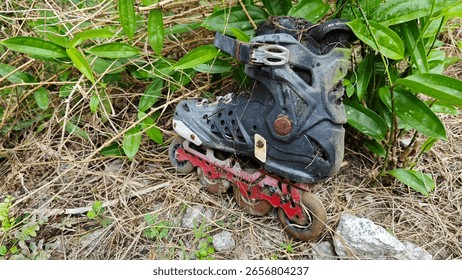 a pair of thrown away wheel inline skating shoe in the ground.