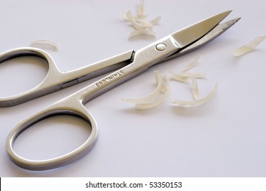 A Pair Of Toe Nail Scissors On Some Nail Clippings