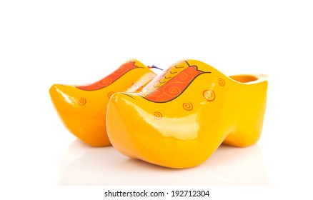 pair of traditional Dutch yellow wooden shoes over white background 