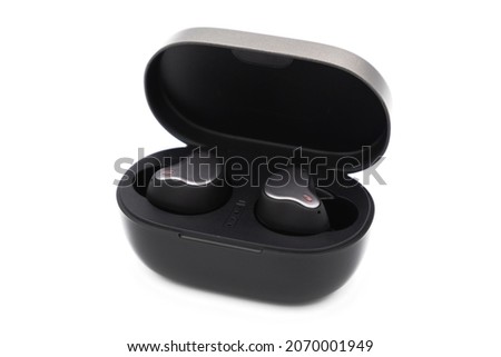 Pair of true wireless earbuds in case isolated on white background