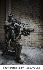 Pair Of US Army Rangers With Machinegun And Rifle Moving Along The Wall After Each Other On Military Mission