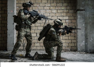 Pair Of US Army Rangers With Machinegun And Rifle Moving Along The Wall After Each Other On Military Mission