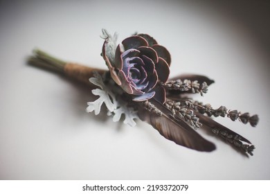 Pair of wedding boutonnieres on a white table.