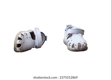 Pair of white baby shoes on the pavement, lost children boots, isolated on white background