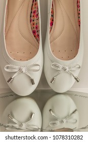 Pair Of White Ballerina Shoes Tip Toe With Reflections In A Mirror Closeup 