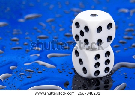 Pair of white dice with black dots - Blue background with water droplets