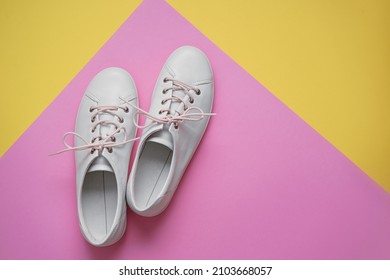 Pair of white gumshoes on colorful background. - Shutterstock ID 2103668057
