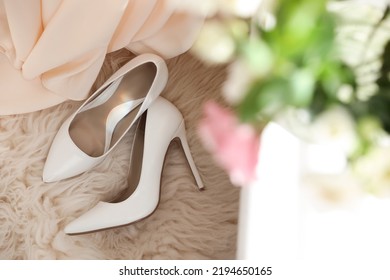 Pair Of White High Heel Shoes And Wedding Dress On Fuzzy Rug, Top View