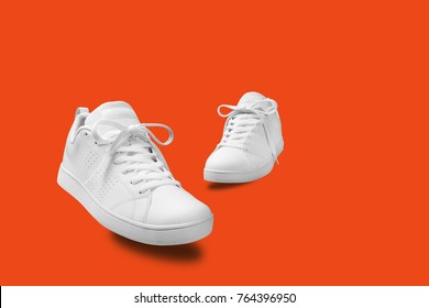 Pair Of White Sneaker Isolated On Orange Background With Clipping Path