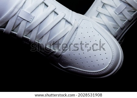 Pair of white sneakers on a black background