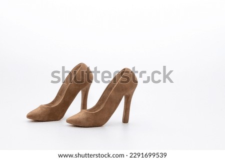 Pair of women's shoes made from wood. A beautiful high-heeled wooden shoes against white background. Handmade shoes for use in female concept