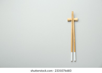 Pair of wooden chopsticks with rest on light grey background, top view. Space for text - Powered by Shutterstock