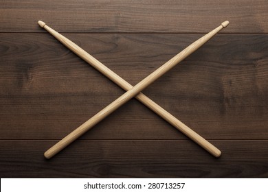 pair of wooden drumsticks crossed on wooden table