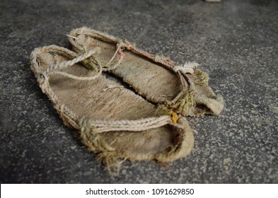 A pair of worn out shoes/sandals made out of grass. Handmade traditional shoes from Shaanxi Province, northern China. Used for farming.