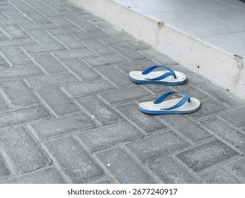 A Pair of Wornout Flipflops Left Behind on a Dusty Pavement, a Tale of Transient Journeys