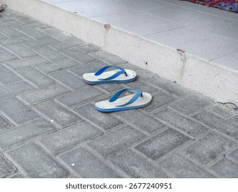 A Pair of Wornout Flipflops Left Behind on a Dusty Pavement, a Tale of Transient Journeys